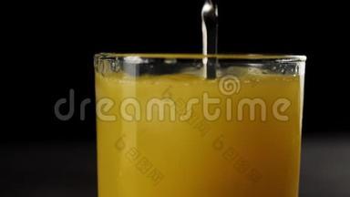 酒保用勺子在黑色背景下用高杯<strong>搅拌</strong>新鲜橙汁<strong>冰块</strong>的侧面视图